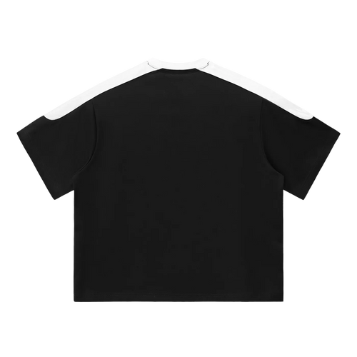 Camiseta oversized negra getabbe con texto "département de design français" en blanco al centro, panel blanco en hombros y cuello redondo en contraste, manga raglán color block, corte holgado unisex, fondo blanco