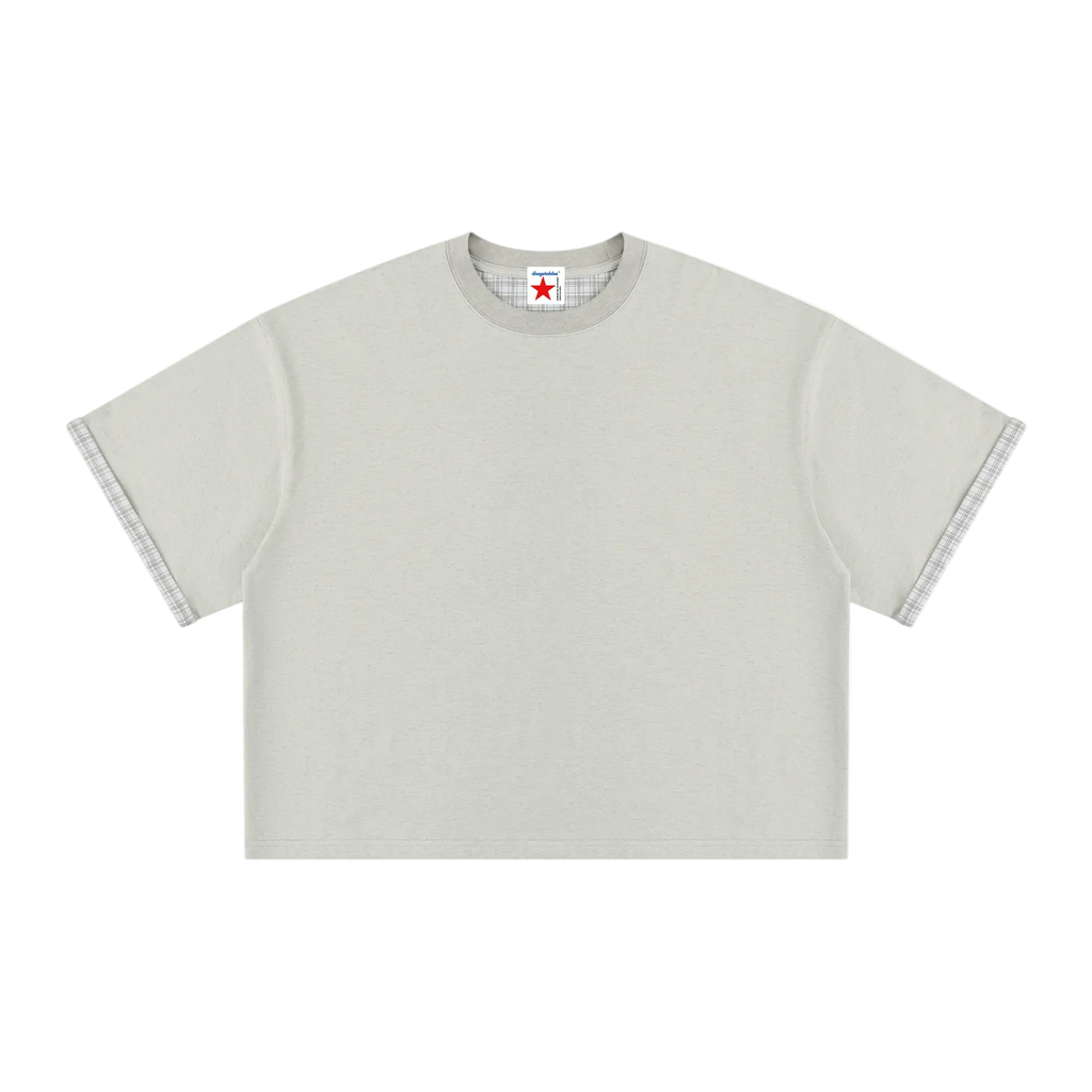 Camiseta gris claro getabbe lisa con puños de manga en tela cuadros gris en contraste, etiqueta diegetabbe con estrella roja en cuello redondo, hombro caído, corte boxy crop holgado unisex, fondo blanco