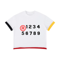 Camiseta blanca getabbe con símbolo ® rojo y números "1 2 3 4 5 6 7 8 9" en negro estilo stencil, puño izquierdo negro, puño derecho amarillo, dobladillo rojo en contraste, cuello redondo, corte crop holgado unisex, fondo blanco