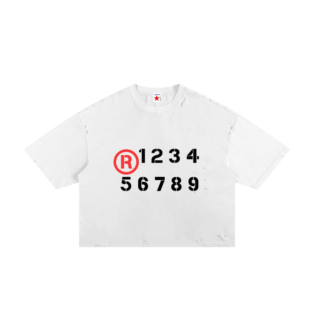 Camiseta blanca getabbe con símbolo ® rojo y números "1 2 3 4 5 6 7 8 9" en negro estilo stencil, acabado ripped distressed en hombros y dobladillo, etiqueta con estrella roja, hombro caído, corte crop holgado unisex, fondo blanco