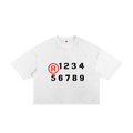 Camiseta blanca getabbe con símbolo ® rojo y números "1 2 3 4 5 6 7 8 9" en negro estilo stencil, acabado ripped distressed en hombros y dobladillo, etiqueta con estrella roja, hombro caído, corte crop holgado unisex, fondo blanco